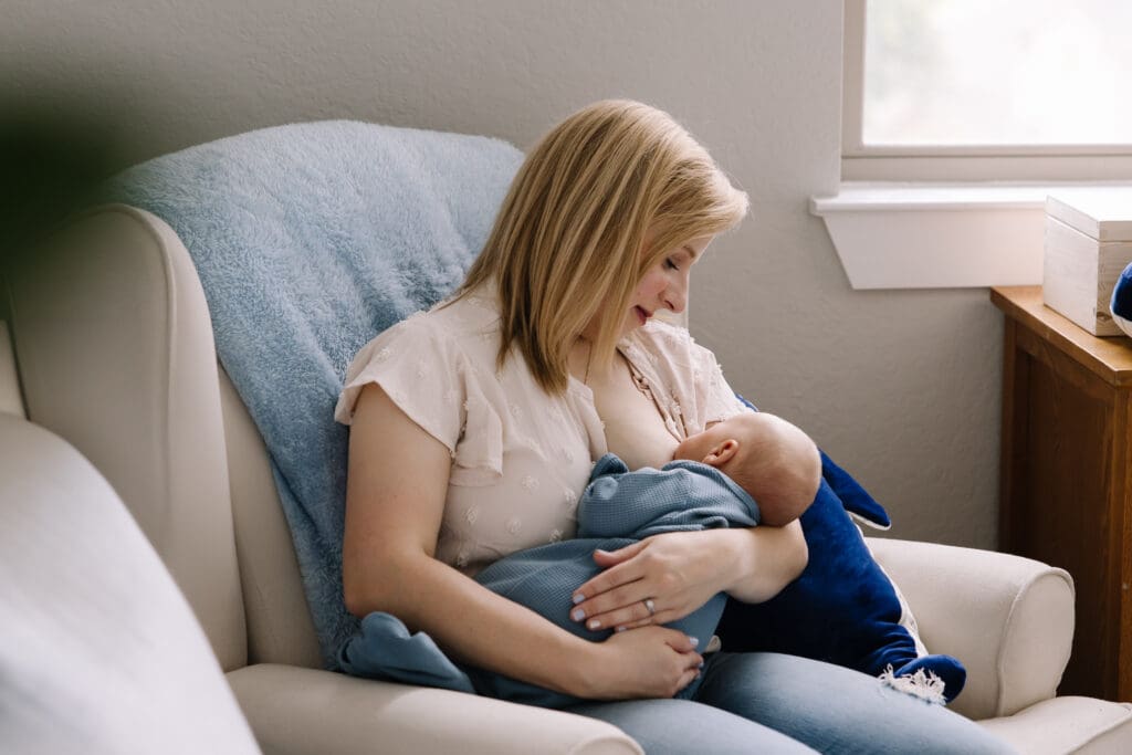 In-home breastfeeding photography session in San Antonio. A natural, candid moment between mother and baby. This lifestyle portrait captures the love, nourishment, and quiet strength of motherhood in a relaxed home environment.
