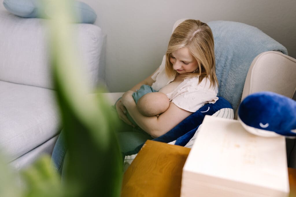 An intimate in-home breastfeeding photography session in San Antonio. Featuring a mother and baby sharing a quiet moment of connection. Captured in natural light, this lifestyle photo highlights the emotional bond and beauty of motherhood. Perfect example of documentary-style breastfeeding photography for families seeking authentic memories at home.
