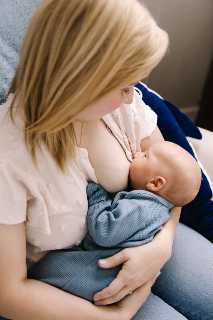 In-home breastfeeding photography session in San Antonio. A natural, candid moment between mother and baby. This lifestyle portrait captures the love, nourishment, and quiet strength of motherhood in a relaxed home environment.