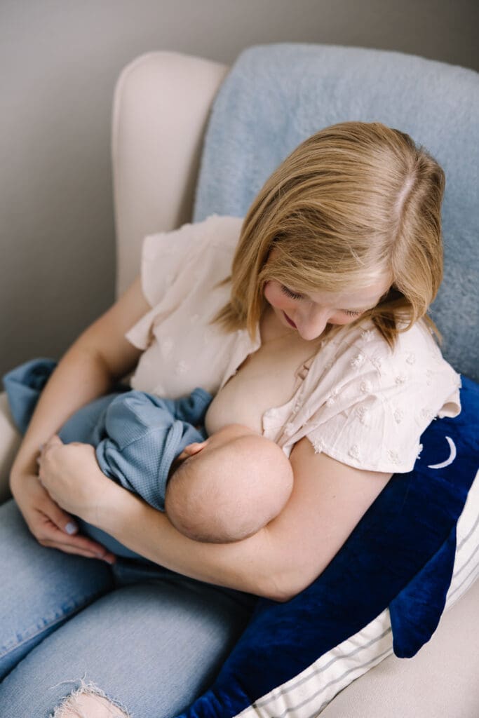 In-home breastfeeding photography session in San Antonio. A natural, candid moment between mother and baby. This lifestyle portrait captures the love, nourishment, and quiet strength of motherhood in a relaxed home environment.