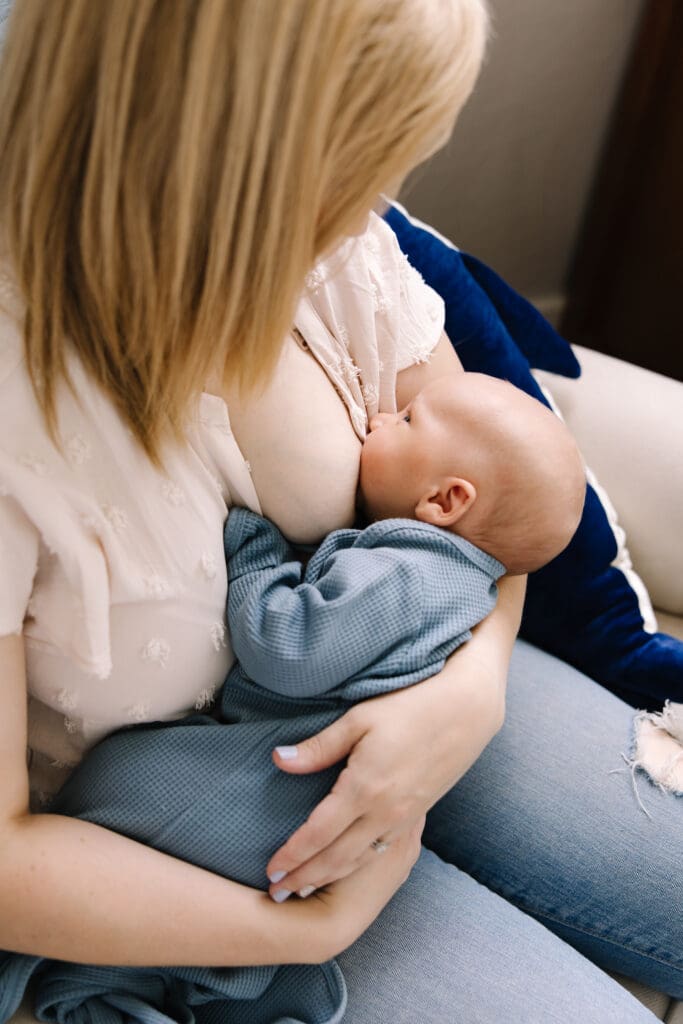 In-home breastfeeding photography session in San Antonio. A natural, candid moment between mother and baby. This lifestyle portrait captures the love, nourishment, and quiet strength of motherhood in a relaxed home environment.