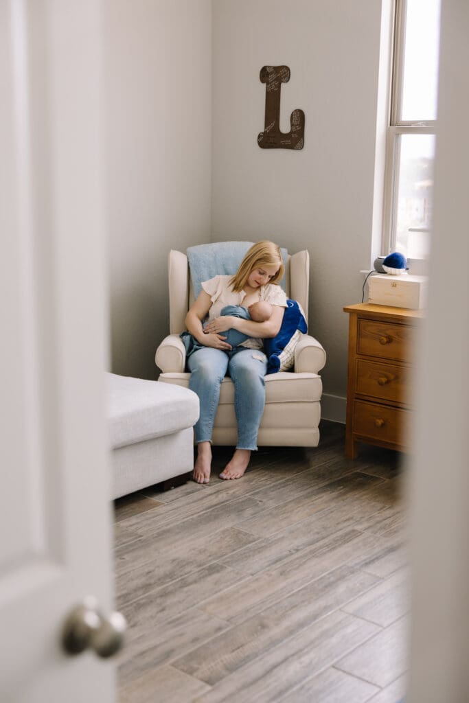 In-home breastfeeding photography session in San Antonio. A natural, candid moment between mother and baby. This lifestyle portrait captures the love, nourishment, and quiet strength of motherhood in a relaxed home environment.