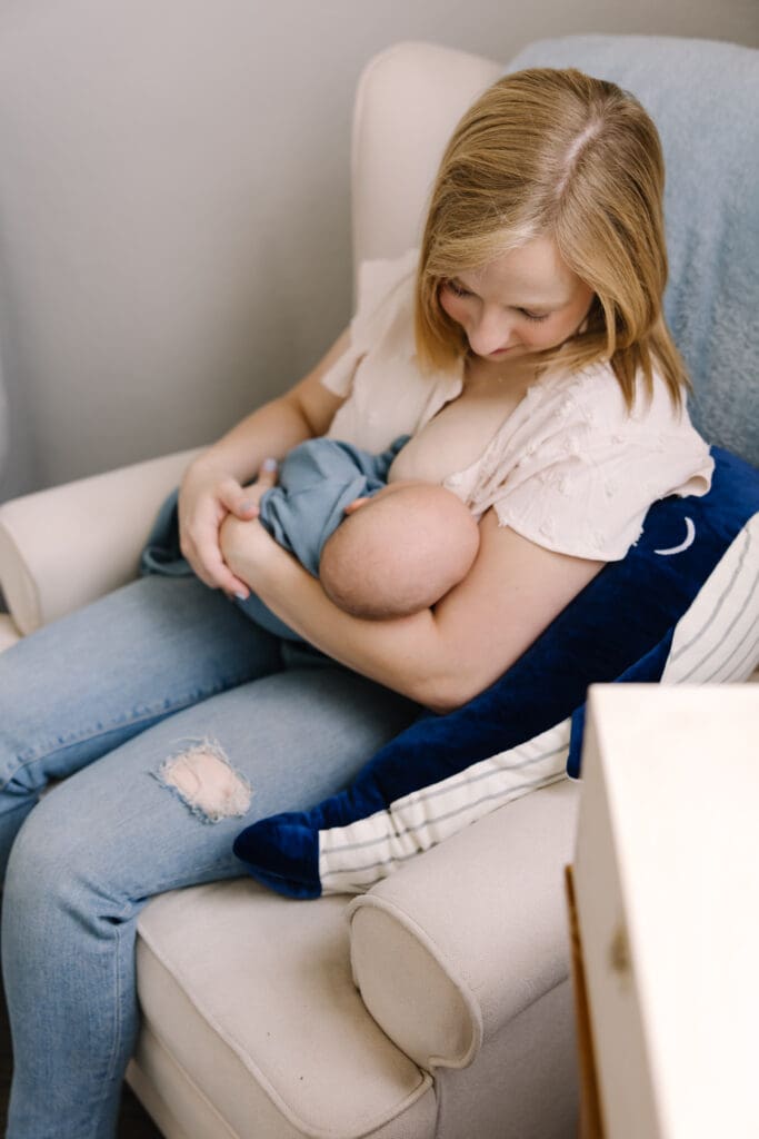 In-home breastfeeding photography session in San Antonio. A natural, candid moment between mother and baby. This lifestyle portrait captures the love, nourishment, and quiet strength of motherhood in a relaxed home environment.